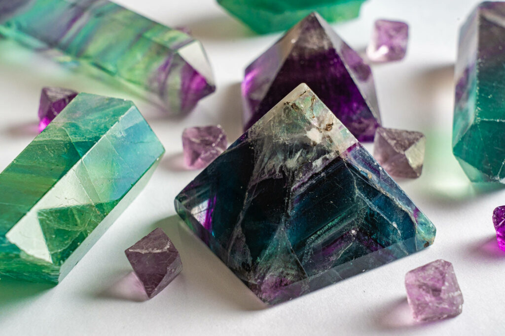 Close-up of pyramid cut amethyst with purple and green faceted crystals on white background Wallpaper