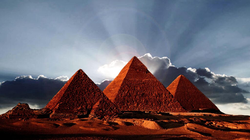 Pyramid sunrise at Giza with golden sunlight and dramatic sky ancient Egyptian landmarks Wallpaper