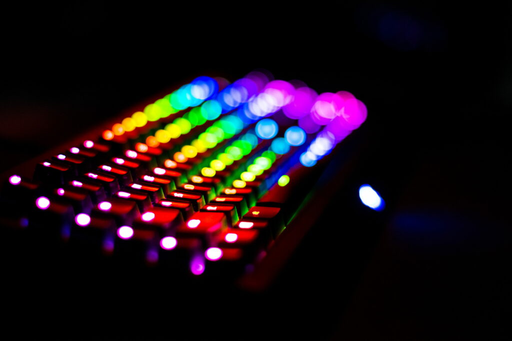 Close-up RGB mechanical keyboard with vibrant rainbow backlit keys and moody bokeh effect Wallpaper