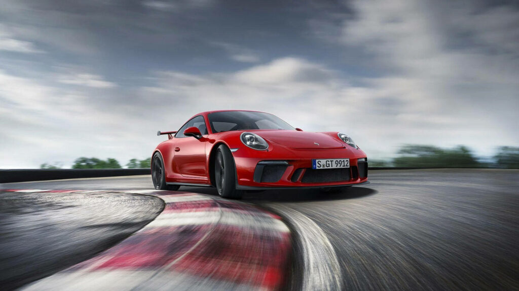 Sharp Turns and Fast Cars: Red Porsche 911 Speeding Desktop Wallpaper
