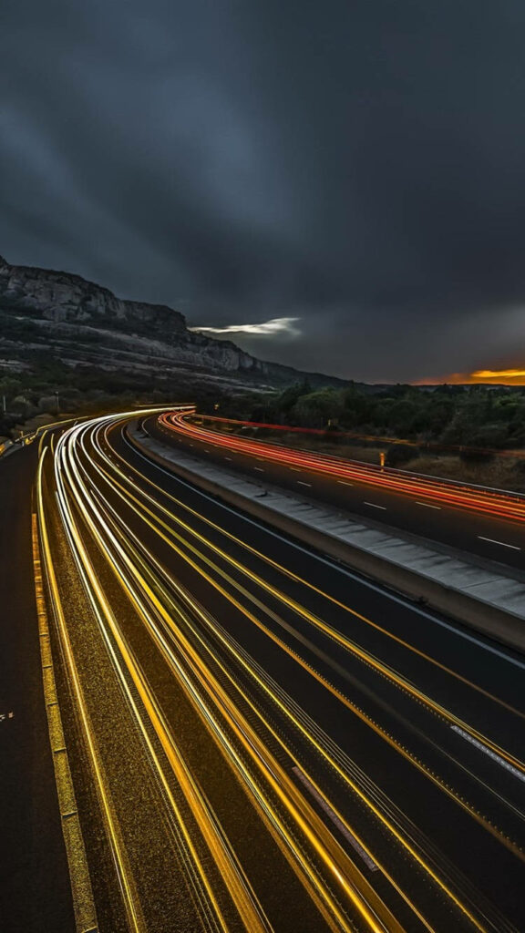 Futuristic Velocity: Capturing the Thrill of High-Speed Travel with Dazzling Light Trails in an iPhone Wallpaper
