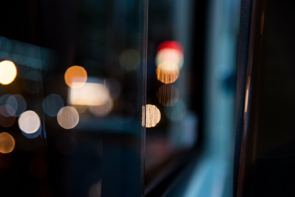 Warm bokeh lights blurred over dark urban window view creating a dreamy minimalist wallpaper background
