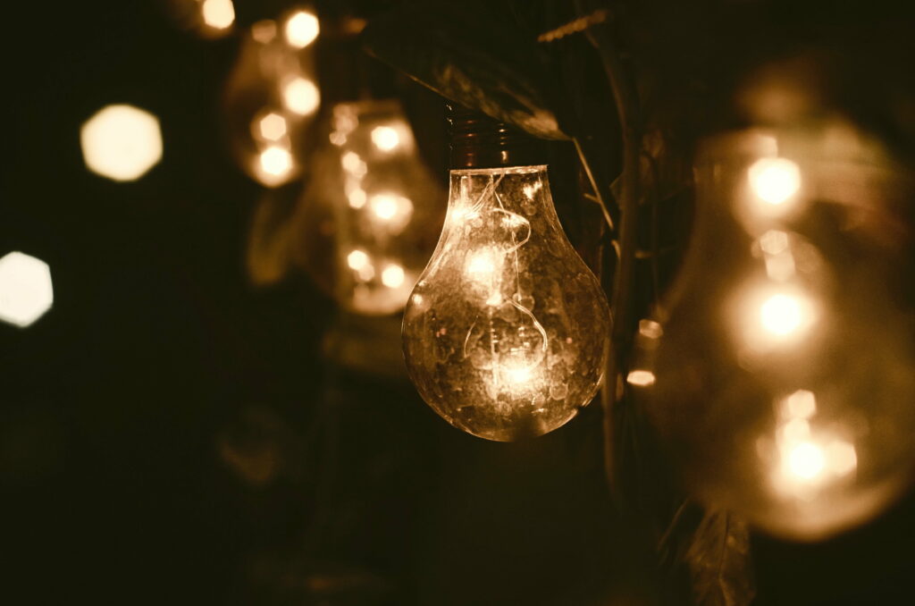 Luminous Festivities: A Vibrant 4K Wallpaper with a Glowing Garland and Shimmering Light Bulb