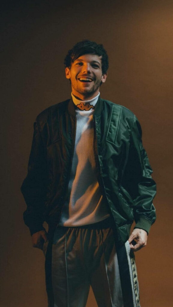 Louis Tomlinson exudes style and charisma in a vibrant ensemble against a backdrop of pure joy Wallpaper