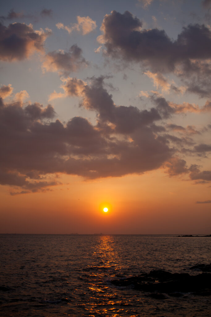 Breathtaking sunset over calm ocean with orange pink sky and silhouetted rocks wallpaper background