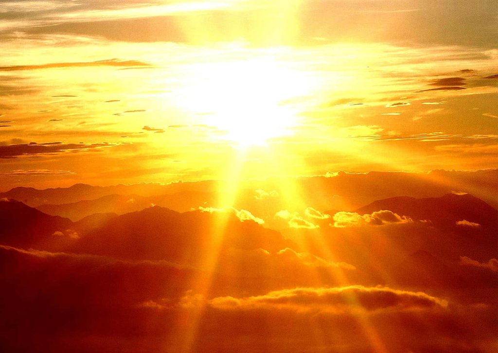 Sunset over silhouetted mountains with warm golden orange hues peaceful landscape wallpaper