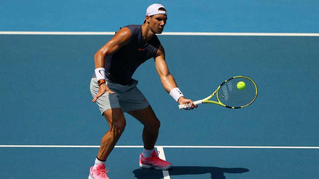 Intense Rafael Nadal Tennis Return on Bright Blue Court Wallpaper