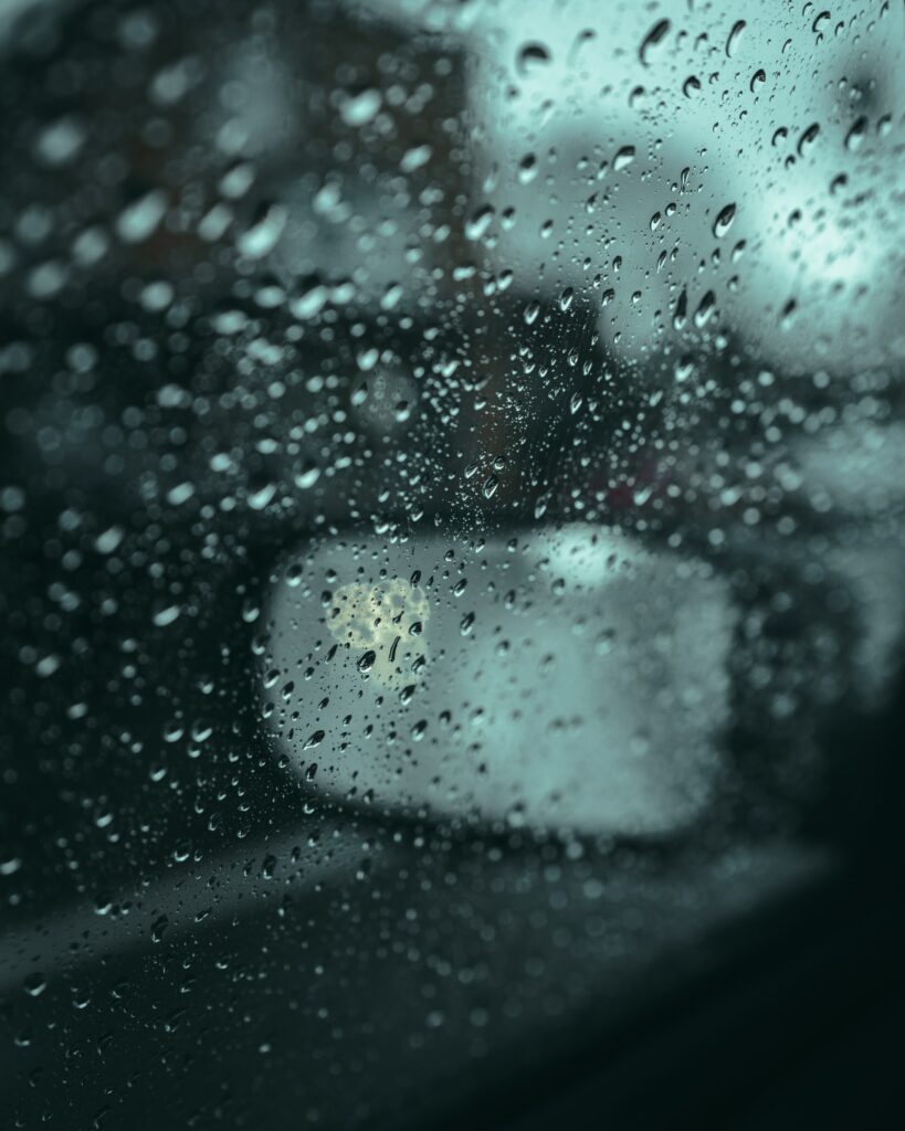 Moody Rain Droplets on Car Window - Blurred Mirror Reflection Wallpaper