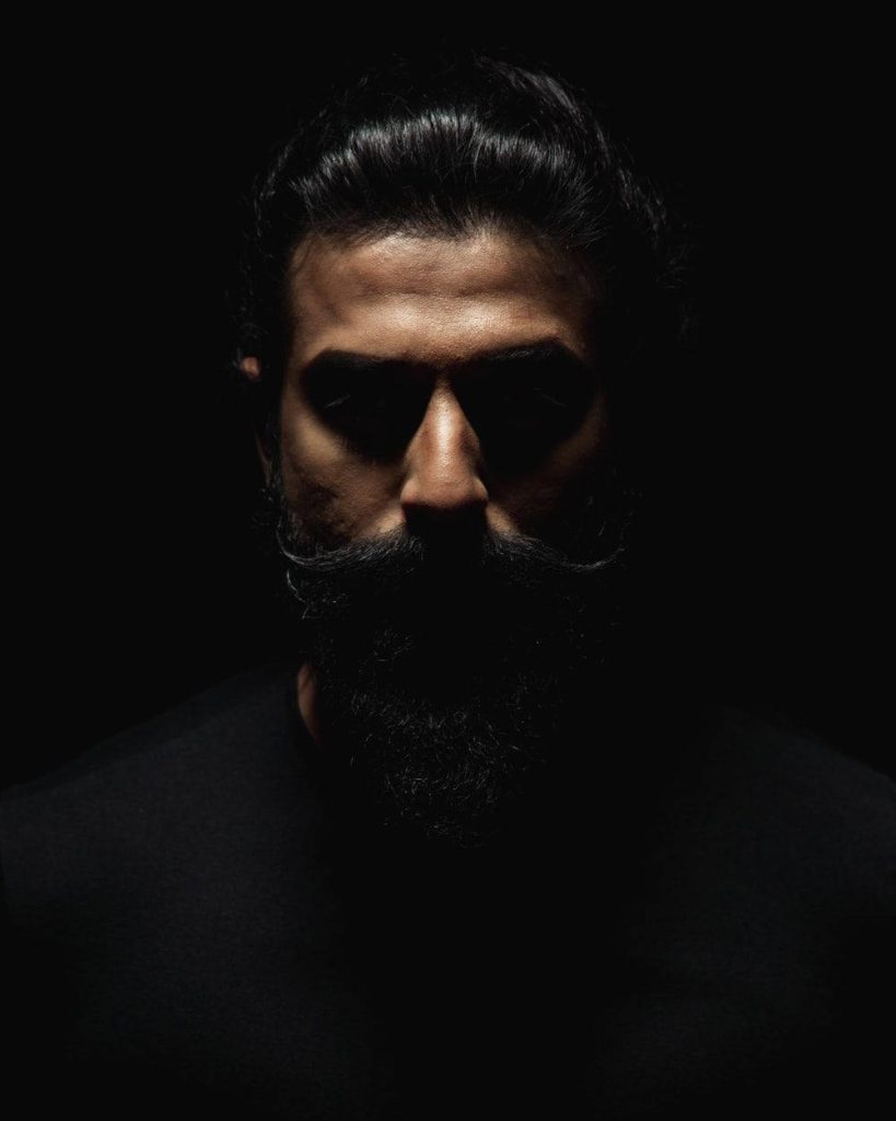 High-contrast portrait of Indian cricketer Ravindra Jadeja with dramatic shadows and beard Wallpaper