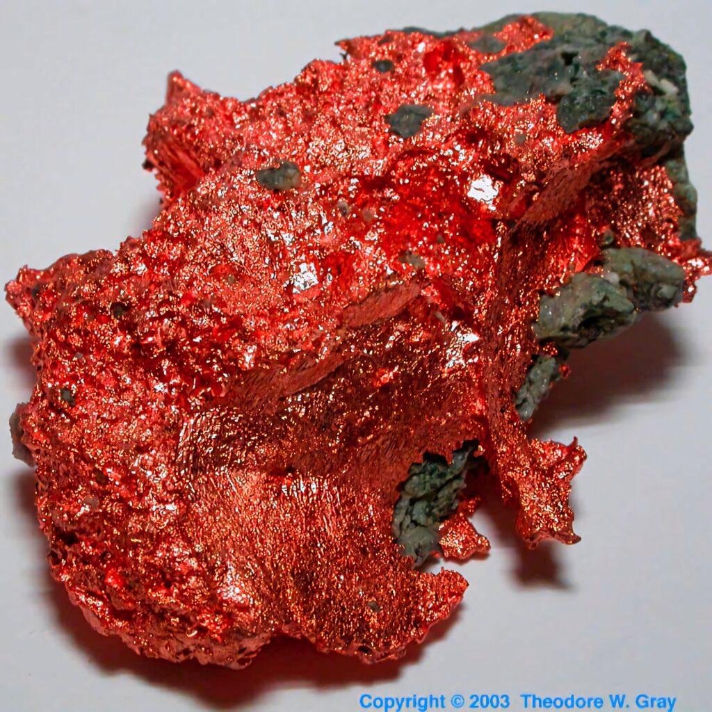 Close-up of raw copper mineral with rich metallic reddish-orange hues and textured surface wallpaper