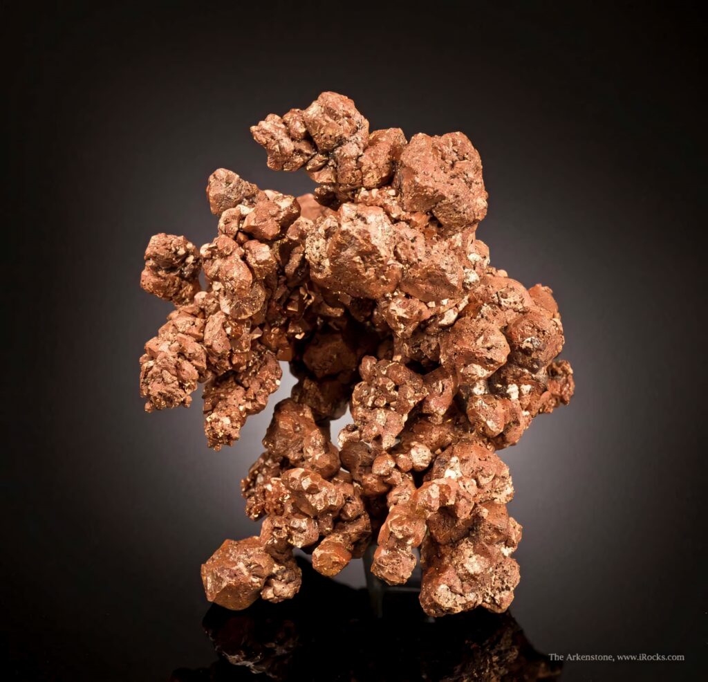 Raw copper ore chunk with metallic luster reddish brown tones rugged crystal texture on dark background Wallpaper