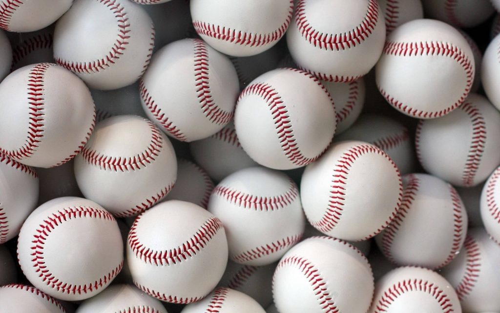 Close-up of realistic baseballs with red stitches and textured white leather on wallpaper background