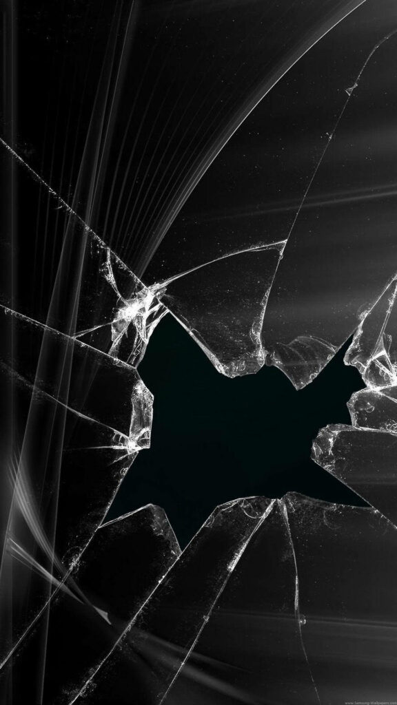 Realistic broken screen wallpaper with large central hole and sharp shattered glass cracks on dark background