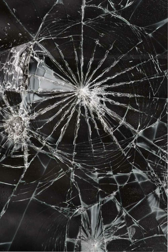 Realistic broken screen wallpaper with detailed cracks and shattered glass on dark background