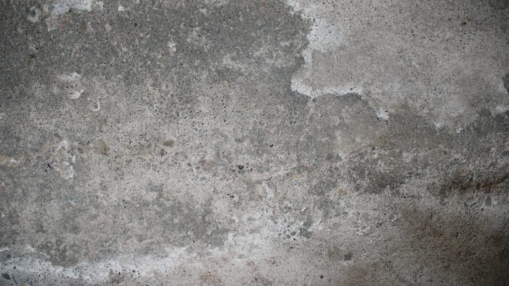 Realistic concrete wallpaper with rough weathered surface and deep grey granular texture background