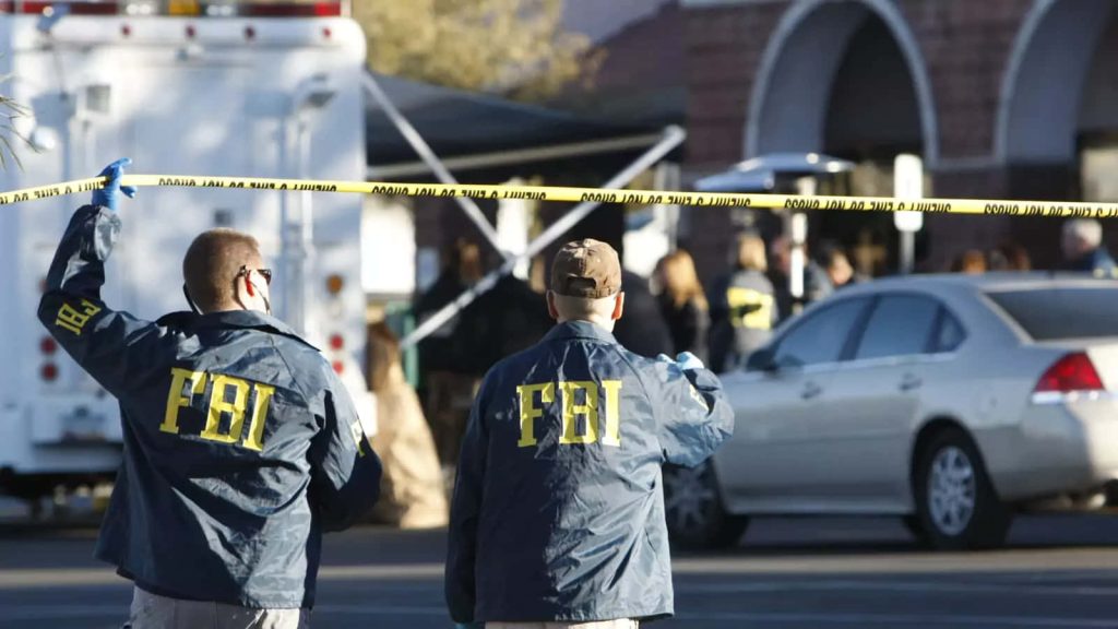 FBI agents in blue jackets investigating behind police tape in daylight urban crime scene wallpaper