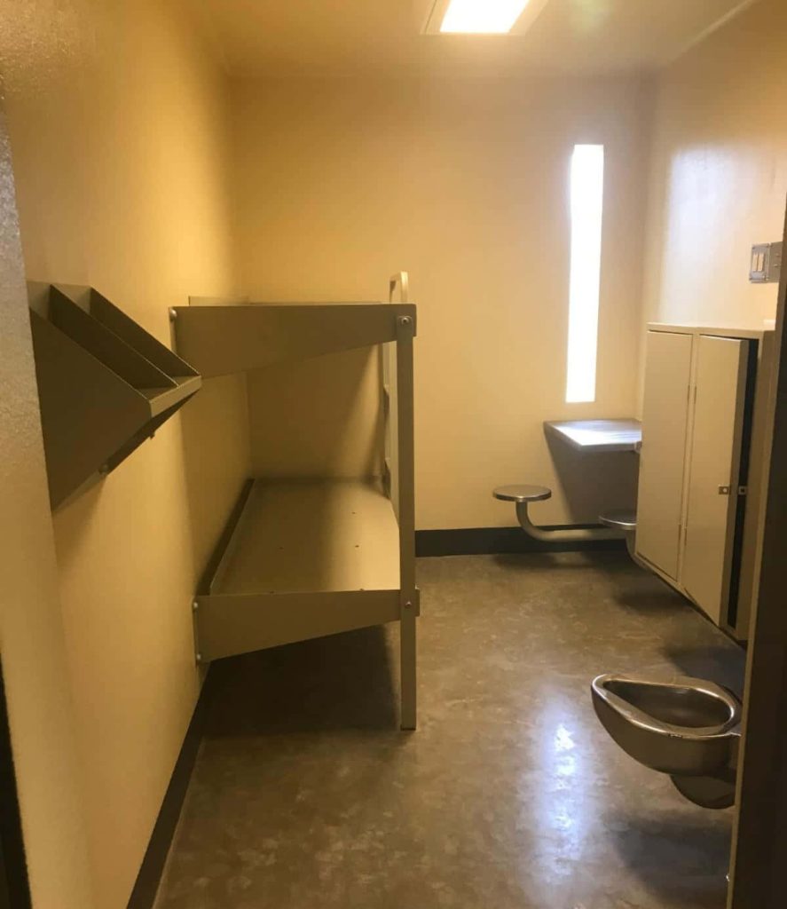 Realistic empty prison cell with metal bunk bed stainless steel toilet-sink and narrow window Wallpaper