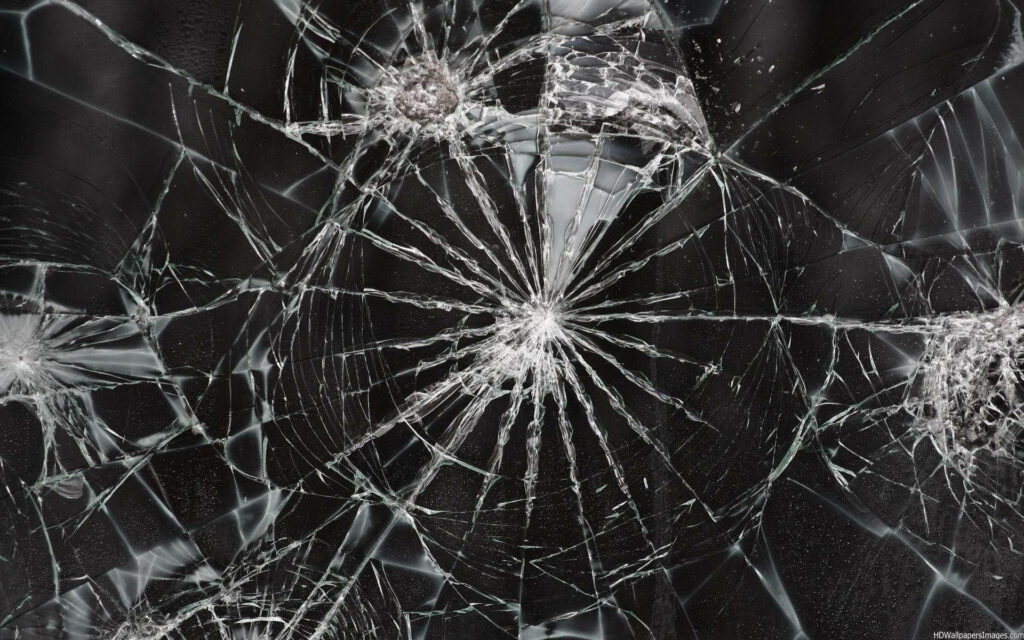Realistic shattered screen wallpaper with spiderweb cracks on dark background for phones desktops