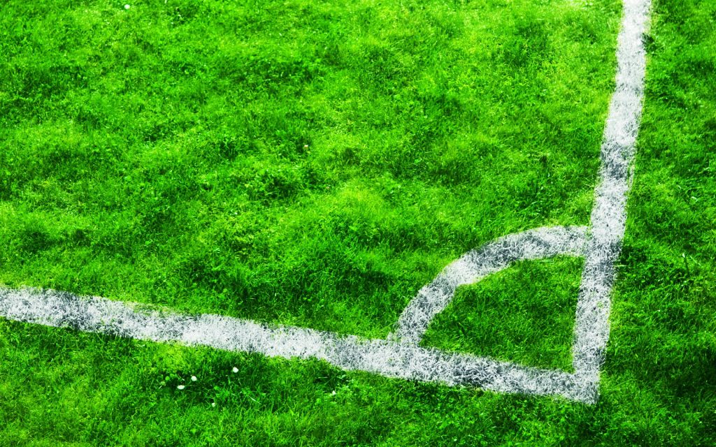 Realistic high definition soccer field corner with vibrant green grass and white markings background Wallpaper
