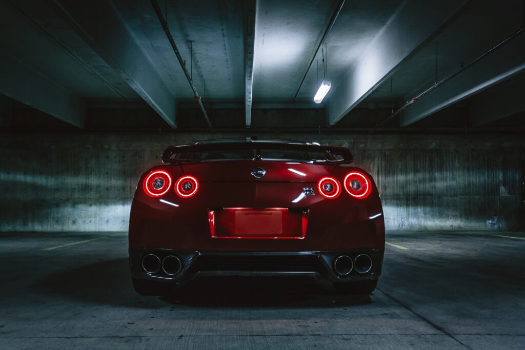 Rear View of Nissan GT-R: Distinctive Taillights in Dim Parking Wallpaper