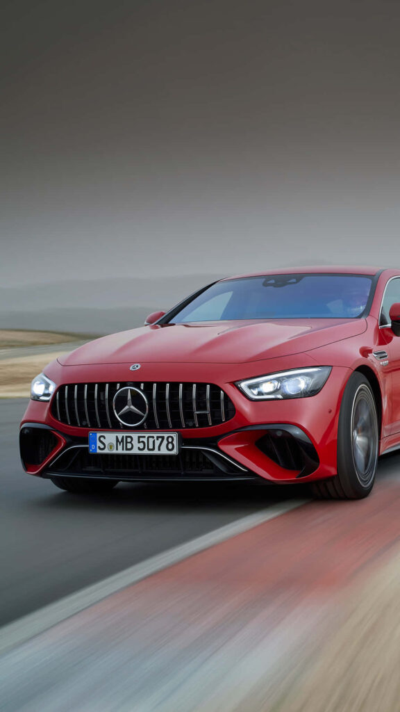 Red AMG GT-R sports car speeding on road showcasing sleek design and powerful presence wallpaper