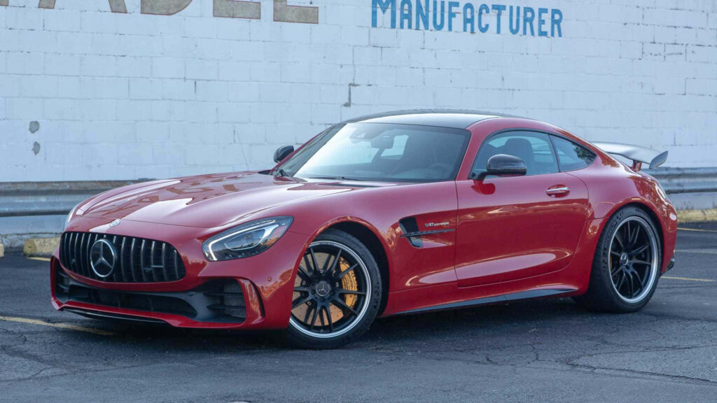 Red AMG GT-R sports car with dynamic design parked in urban cityscape background wallpaper