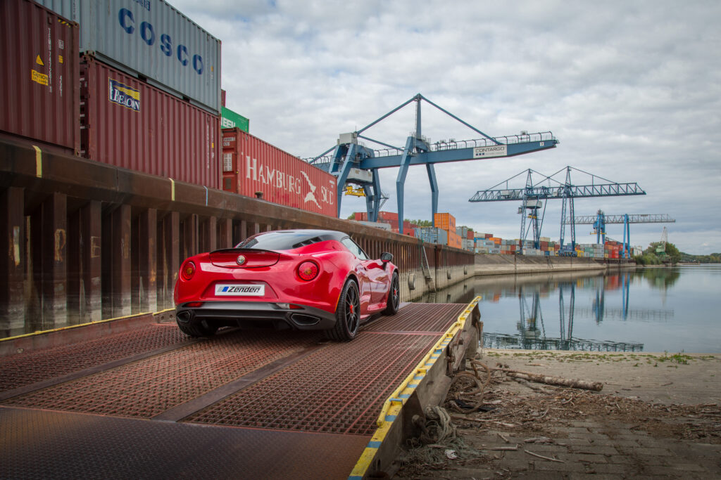 Stunning Red Alfa Romeo 4C Zender in Industrial Shipping Scene Wallpaper