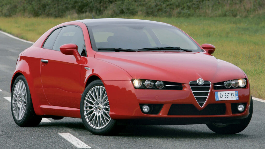 Red Alfa Romeo Brera driving on open road showcasing sleek sporty Italian design wallpaper