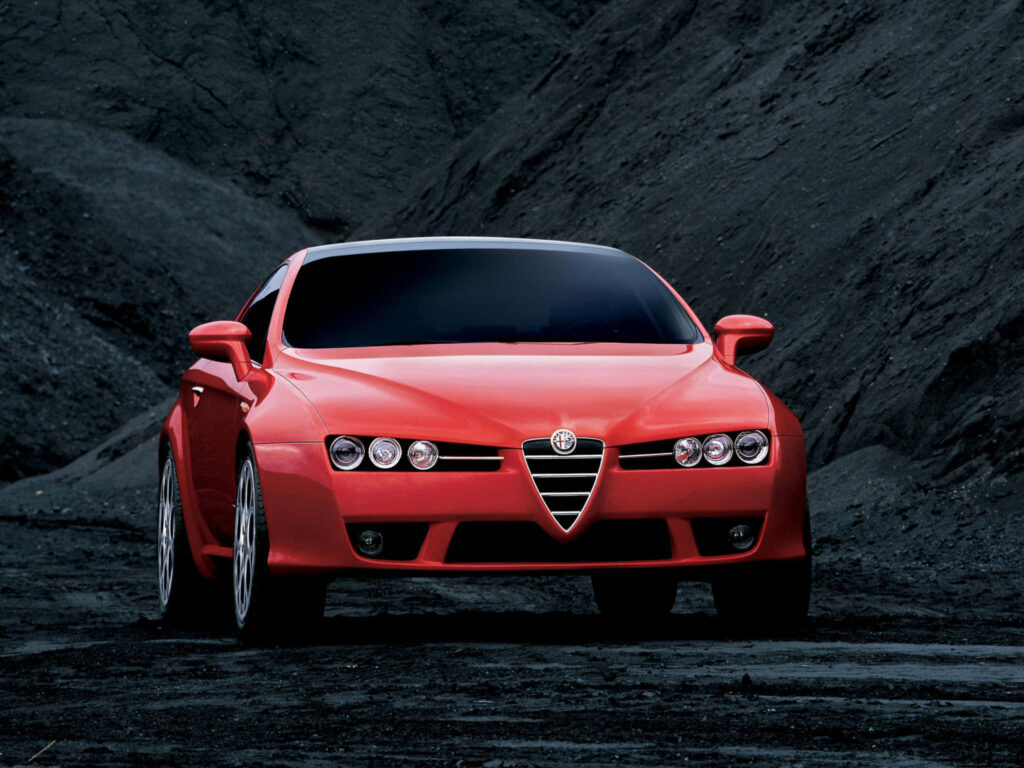 Red Alfa Romeo Brera car on rocky landscape showcasing sleek design and bold presence wallpaper
