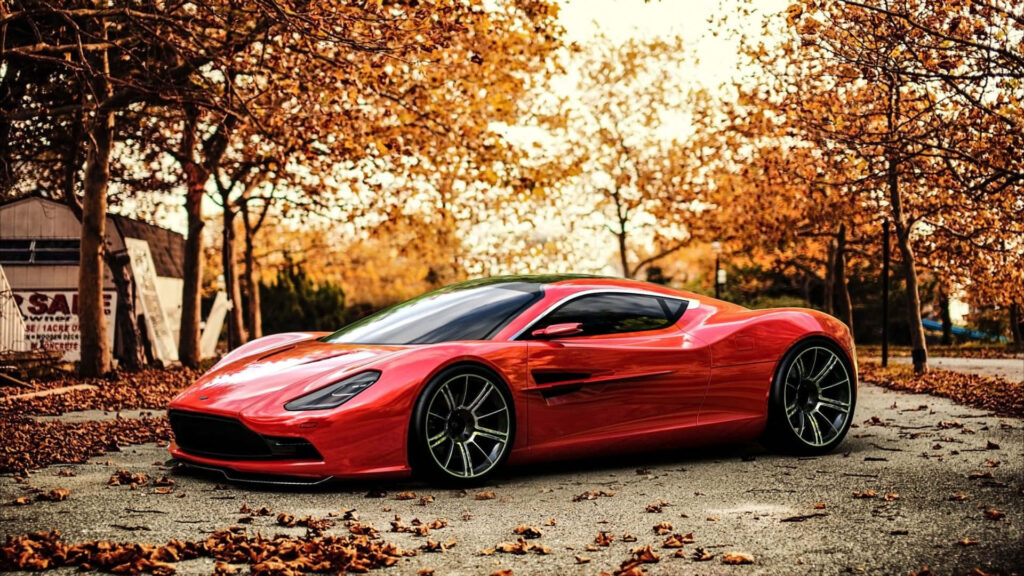 Elegant Red Aston Martin DBS Wallpaper Amidst Fall Foliage