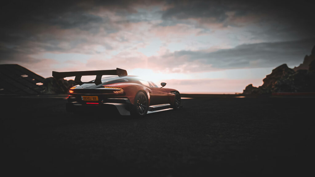 Red Aston Martin sports car in Forza 4 wallpaper with sunset sky and dynamic reflections