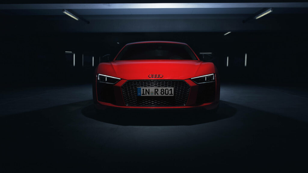 Red Audi R8 in dim parking garage showcasing sleek lines aggressive front grille wallpaper