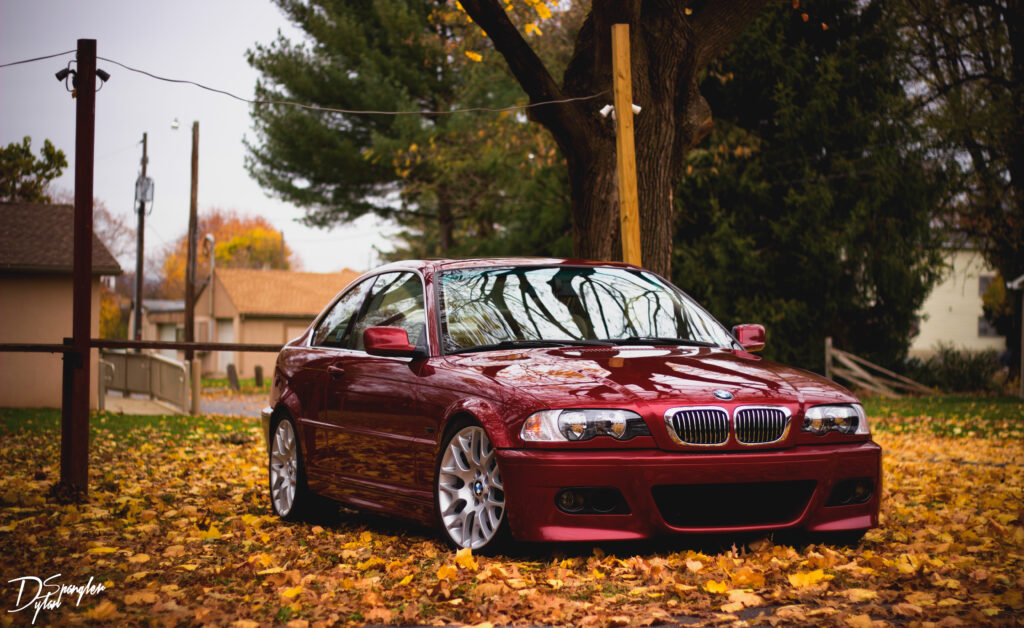 Red BMW Side View Amidst Autumn Foliage - Stunning Seasonal Background Wallpaper