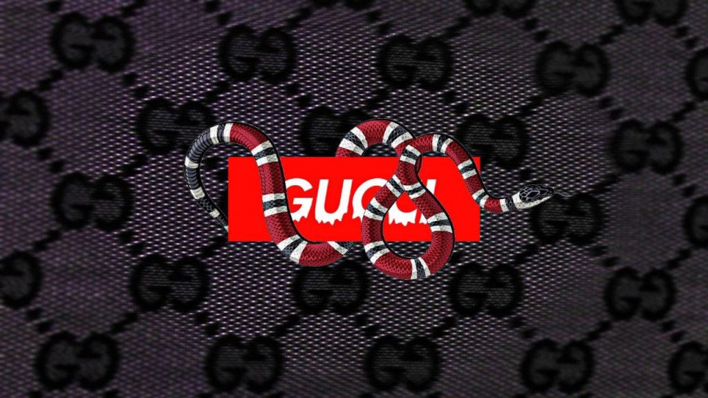 Coiled red black Kingsnake on dripping Gucci box logo with dark GG monogram wallpaper background