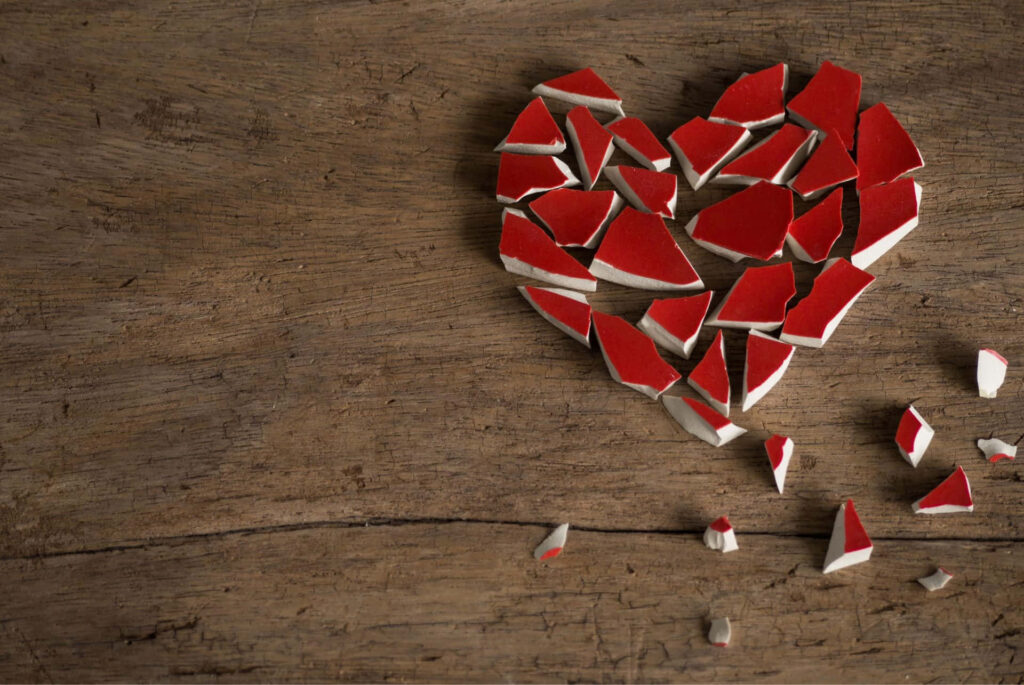 Rustic Wallpaper: Shattered Red Heart Symbolizing Heartbreak