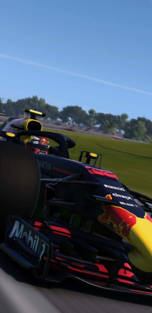 Red Bull Racing 2018 F1 car speeding on track with green trees and clear blue sky background Wallpaper
