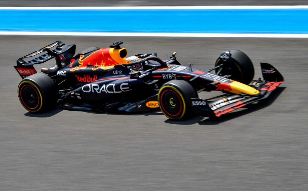 Red Bull Racing car speeding on racetrack vibrant team colors dynamic design wallpaper background