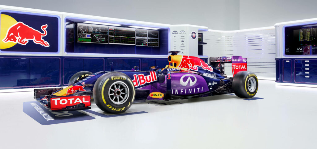 Red Bull Racing Formula 1 car in modern garage with Infiniti Total sponsors and Red Bull branding Wallpaper