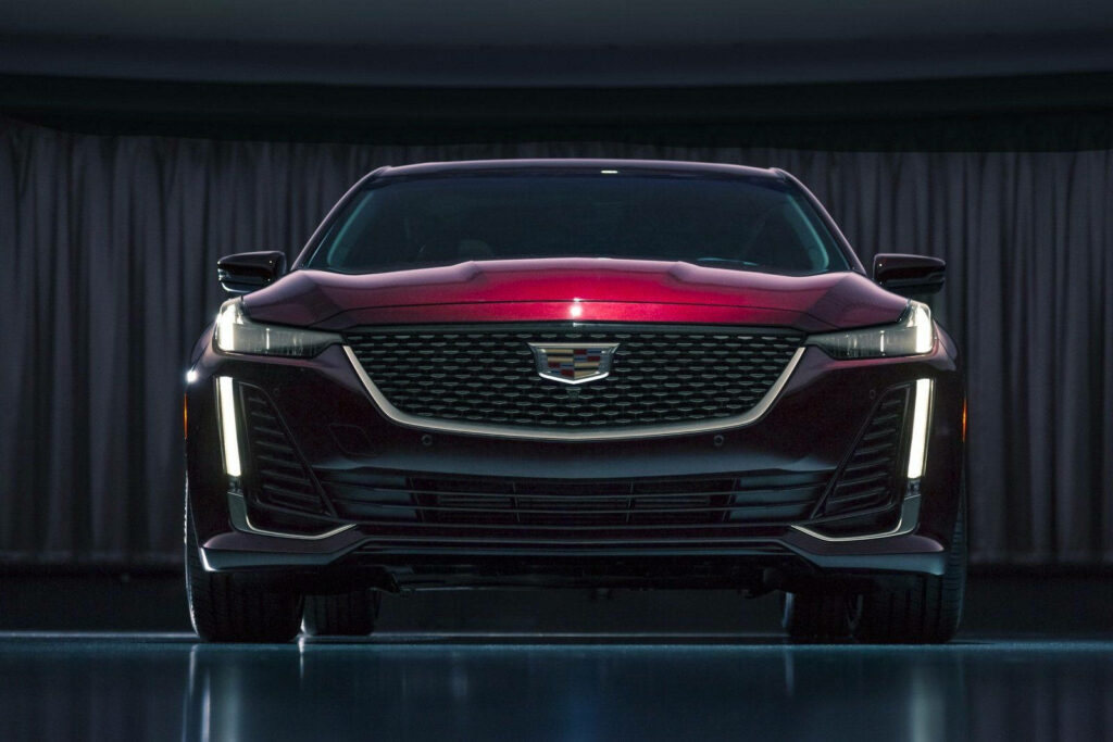 Front view of red Cadillac CT5 with bold grille sleek LED headlights and glossy finish wallpaper