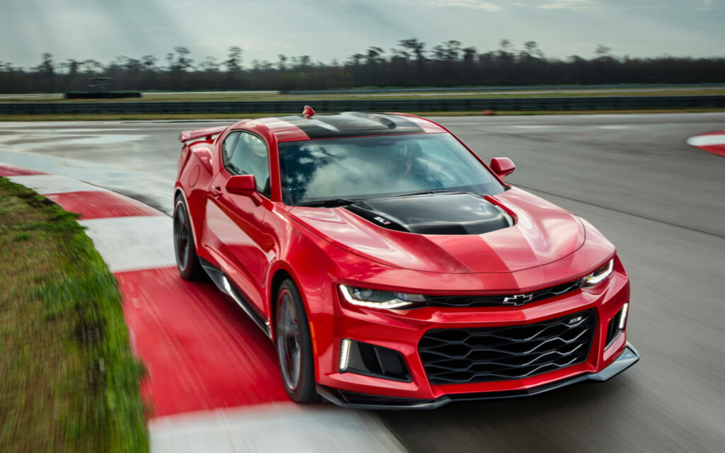 Red Camaro muscle car speeding on racetrack showcasing bold design and powerful performance Wallpaper