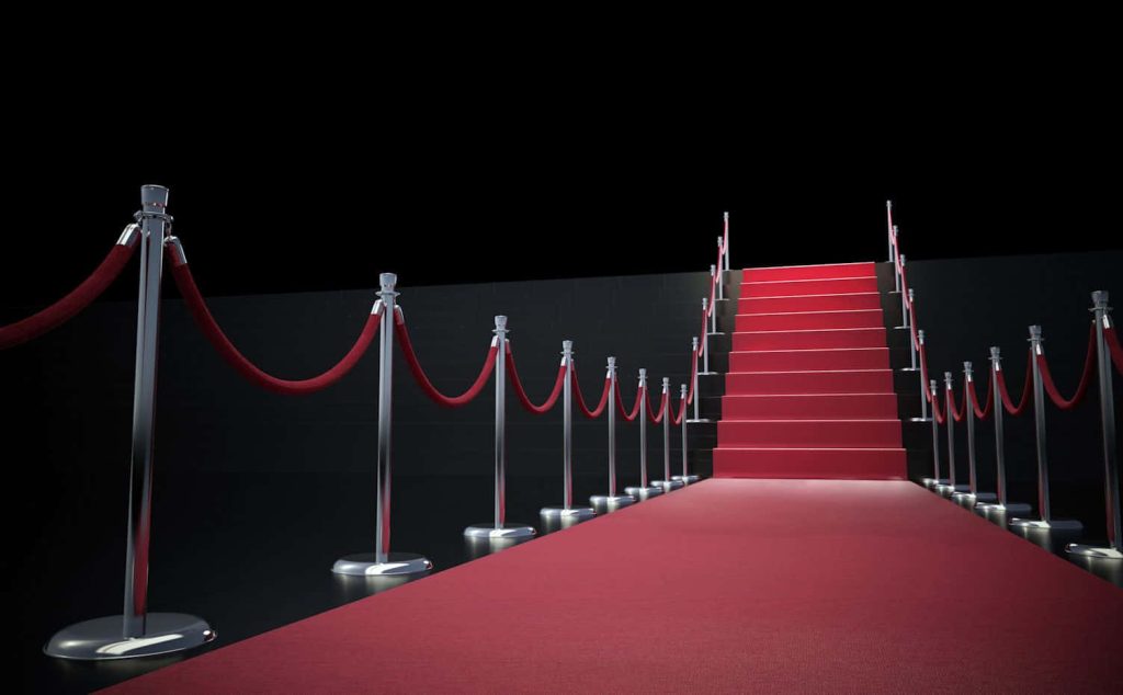 Red carpet wallpaper with velvet ropes chrome stanchions grand event VIP cinematic background