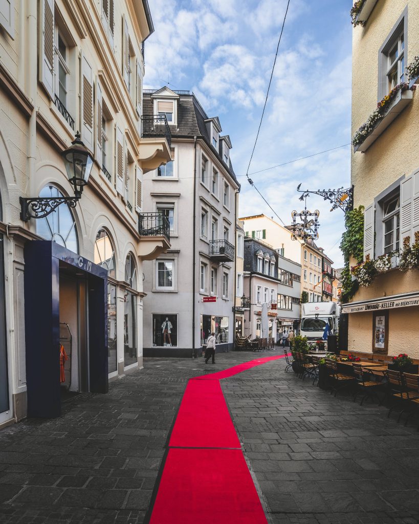 Red carpet on charming European cobblestone street with historic architecture and Löwenbräu-Keller façade Wallpaper