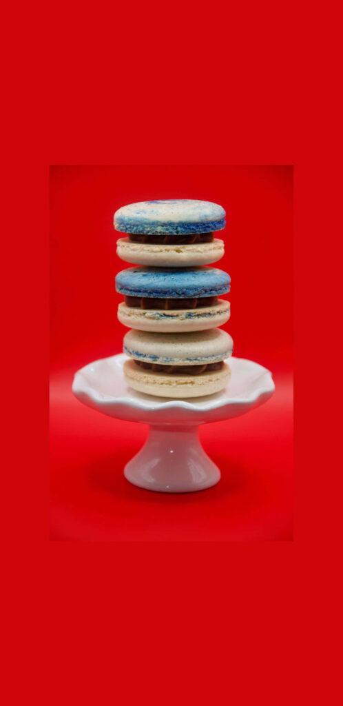 Pastel Macarons Stand in Vibrant Contrast Against Fiery Backdrop Wallpaper