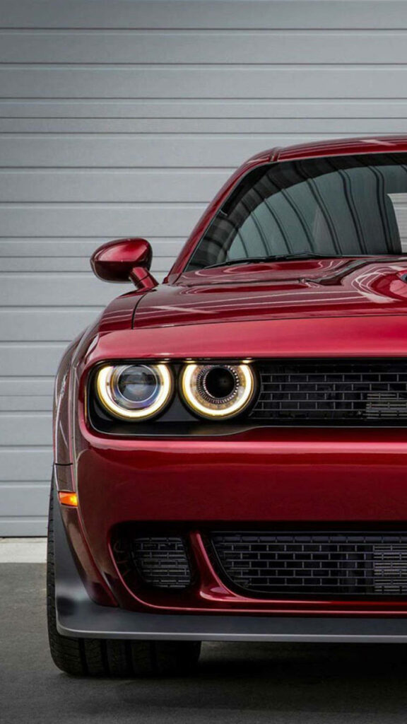 Front view of bold red Dodge Challenger with iconic headlights and aggressive styling wallpaper