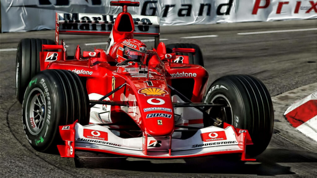 Close-up of red F1 racing car speeding through track corner capturing motorsport intensity Wallpaper