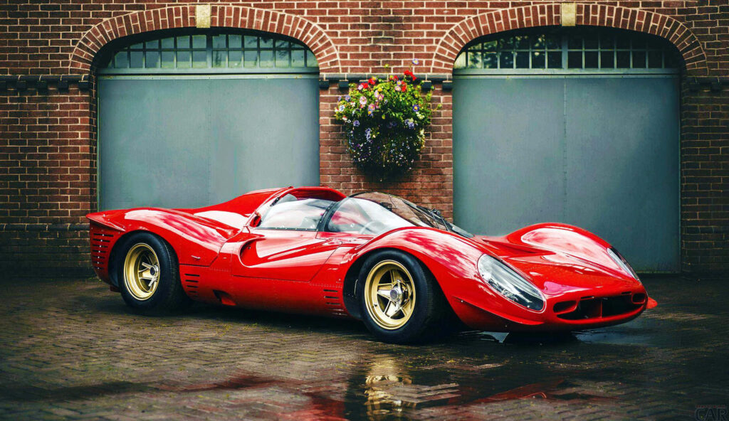 Red Ferrari 330 vintage sports car parked by rustic brick garage doors sleek racing design Wallpaper