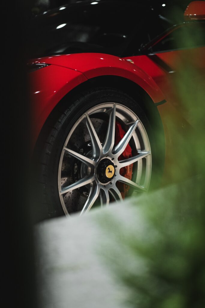 Close-Up of Red Ferrari: Sleek Design & Detailed Alloy Wheel Wallpaper