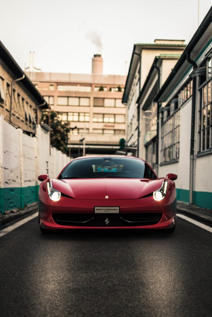 Red Ferrari Sports Car on Urban Street: Elegance and Power Wallpaper