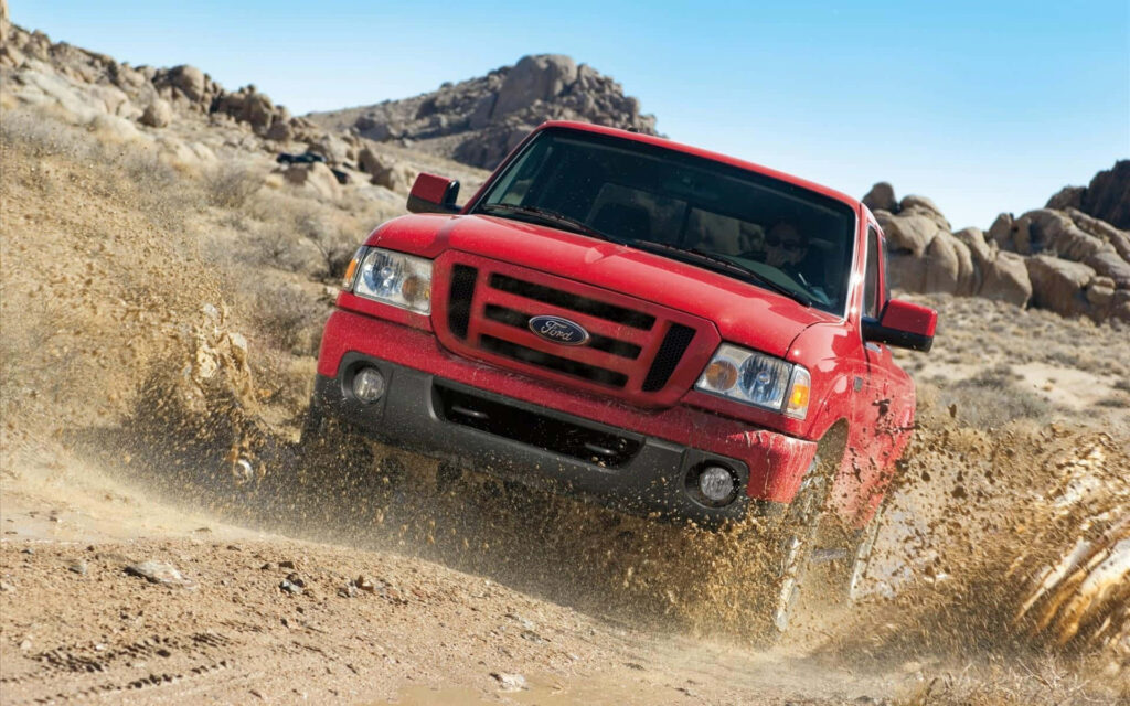 Red Ford Ranger driving off-road in desert kicking up dirt showing rugged power and strength Wallpaper