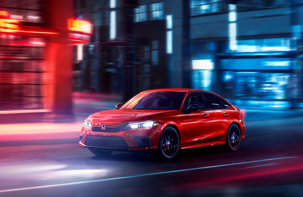 Red Honda Civic speeding through vibrant cityscape at night with dynamic motion blur in 4K Wallpaper
